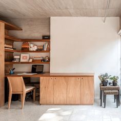 a desk and chair in a room with wooden shelves