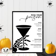 a black and white poster sitting on top of a table next to two pumpkins