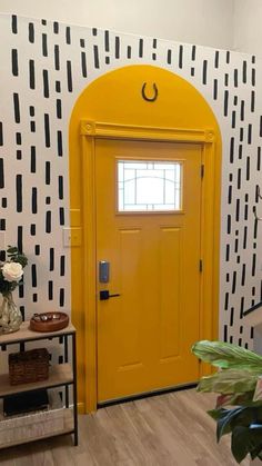 a bright yellow door is in front of a black and white wall