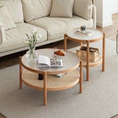 a living room with two coffee tables and a couch in front of the table is an open book