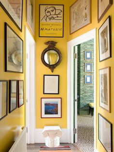 a hallway with yellow walls and pictures on the wall