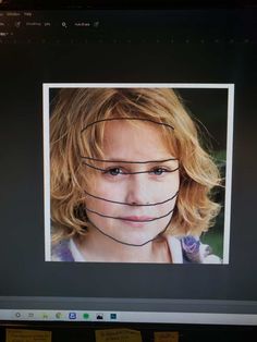 a woman's face with lines drawn across the forehead and behind her head, in front of a computer screen