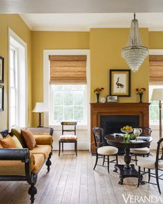 a living room filled with furniture and a fire place under a chandelier above a fireplace