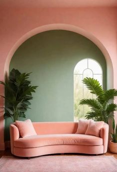 a living room with a pink couch and potted plants on the floor in front of an arched window