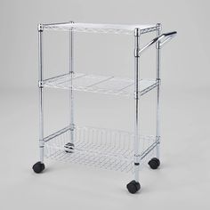 a white rolling cart with two shelves and wheels on the bottom, in front of a gray background