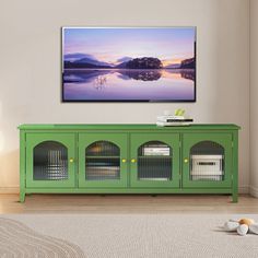 a flat screen tv mounted on the wall above a green cabinet in a living room