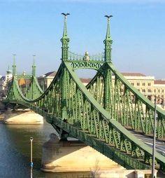 a green bridge spanning the width of a body of water