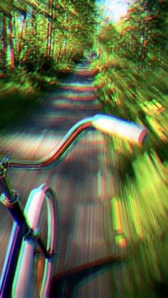 a blurry image of a bike on a road with trees in the back ground