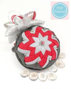 an ornament with red and white flowers on it, surrounded by pearl beads