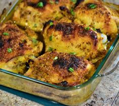 a glass casserole dish filled with chicken and cheese covered in green garnish