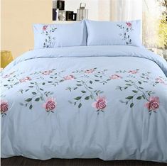 a blue bed with pink roses on it