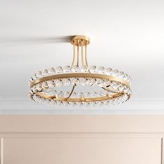 a chandelier hanging from the ceiling in a room with beige walls and white carpet