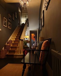 a living room filled with furniture and a chandelier hanging from the side of a wall