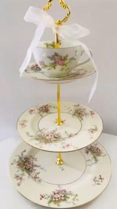 three tiered cake stand decorated with flowers and gold trimmings, holding two plates