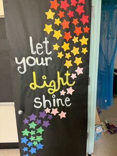 a door decorated with colorful stars and let your light shine written on the front side