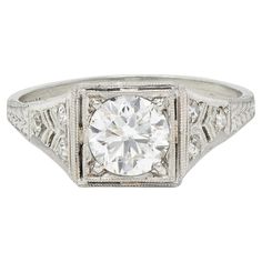 an antique style diamond ring with filigrees on the sides and a center stone