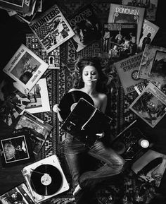 a woman laying on top of a pile of records