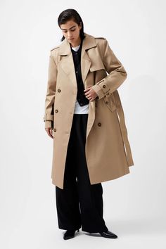 Woman wearing a beige trench coat over a black outfit with wide-leg pants. Longline Trench Coat, D Ring Belt, Ring Belt, Millinery Hats, Workwear Fashion, Jean Accessories, Women's Coats & Jackets, Ticks