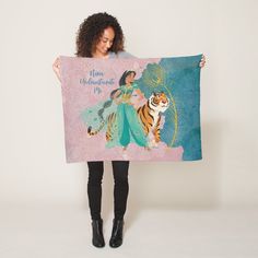 a woman holding up a towel with an image of a tiger and princess on it