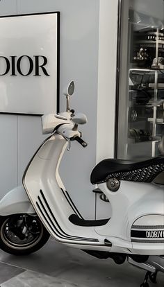 a white scooter parked in front of a building with a logo on it