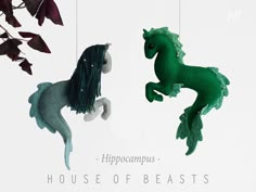 two green horses hanging from strings in front of a white background with the words hippocampus - house of beasts