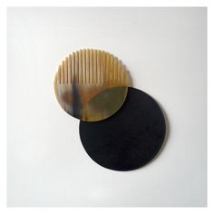 two black and gold plates sitting next to each other on a white surface with an oval shaped object in the middle