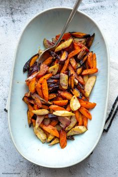 a white bowl filled with carrots and other vegetables