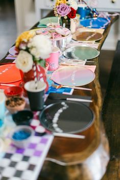 a long table with many plates and vases on it, along with other decorations