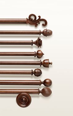 a set of six wooden curtain rods with decorative finials and scrolled handles