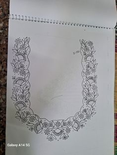 an image of a drawing on paper with flowers and leaves in the shape of a letter u