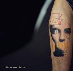 a man's arm with an abstract portrait painted on it