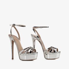 Luxury Silver Sandals For Night Out, Chic Luxury Silver Sandals, Luxury Silver Chic Sandals, Luxury Silver Heels With Padded Heel, Luxury Silver Court Shoes With Branded Heel Counter, Luxury Silver Heels For Party Season, Luxury Trendy Platform Heels, Luxury Trendy Platform Boots, Luxury Metallic Heels For Cocktail