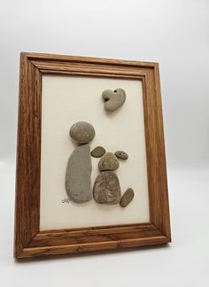 some rocks in a wooden frame on a white surface