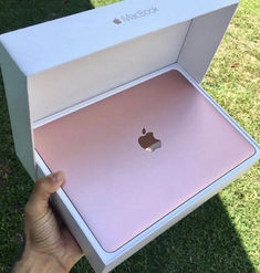 someone holding an apple macbook pro in their hand, with the box open to show it's new design