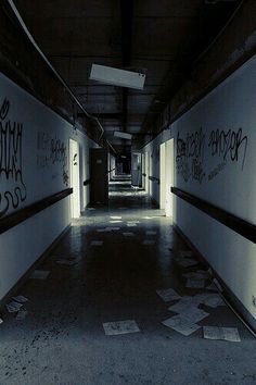 an empty hallway with graffiti on the walls