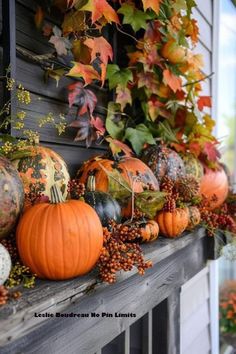 pumpkins and gourds are sitting on the mantle