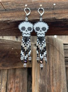 the beaded skull earrings are hanging from hooks