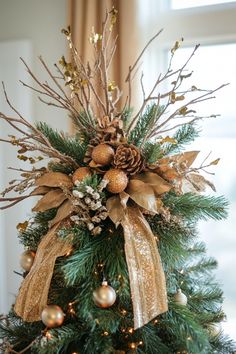 Elegant Christmas tree adorned with gold ribbons, pine cones, glittery ornaments, and twinkling lights. Rustic Woodland Christmas Tree, How To Make A Christmas Tree Topper, Magnolia Christmas Tree, Christmas Tree Topper Rustic, Christmas Tree Toppers Ideas Diy, Christmas Tree Game, Unique Tree Toppers