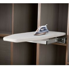 an ironing board is sitting on top of a shelf