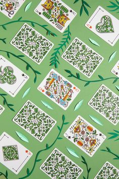 a green background with playing cards and leaves on it, all in the same pattern