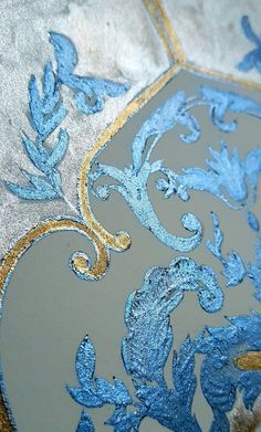 an ornate blue and gold design on a piece of fabric