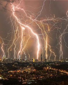 lightning strikes over the city at night time