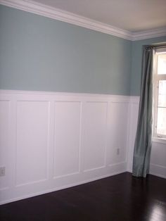 empty room with blue walls and wood flooring on the side, along with white waives