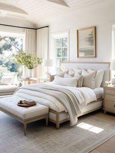 a large white bed sitting in a bedroom next to two windows