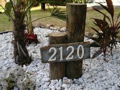 a wooden sign sitting on top of a pile of rocks