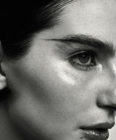 black and white photograph of a woman's face with ear piercings on her ears