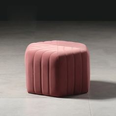 a pink stool sitting on top of a cement floor