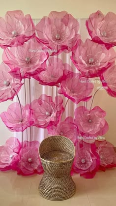 large pink flowers are in front of a sheer curtain with pearls on the top and bottom