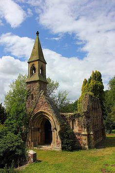 an old church with a steeple surrounded by trees