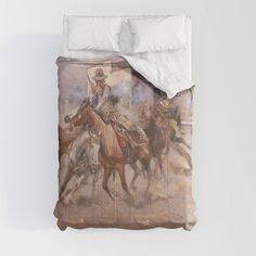 a bed with a painting of cowboys riding horses on the cover and pillowcases